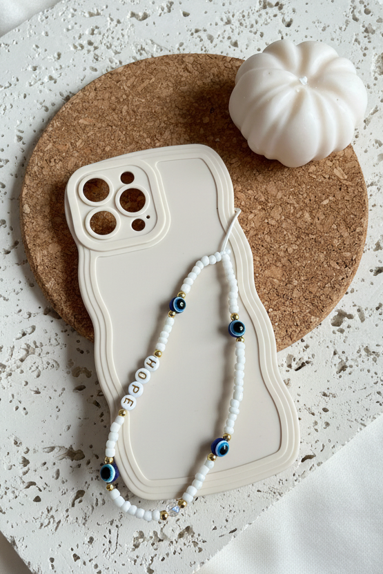 Phone case with a beaded necklace draped over it on a textured surface