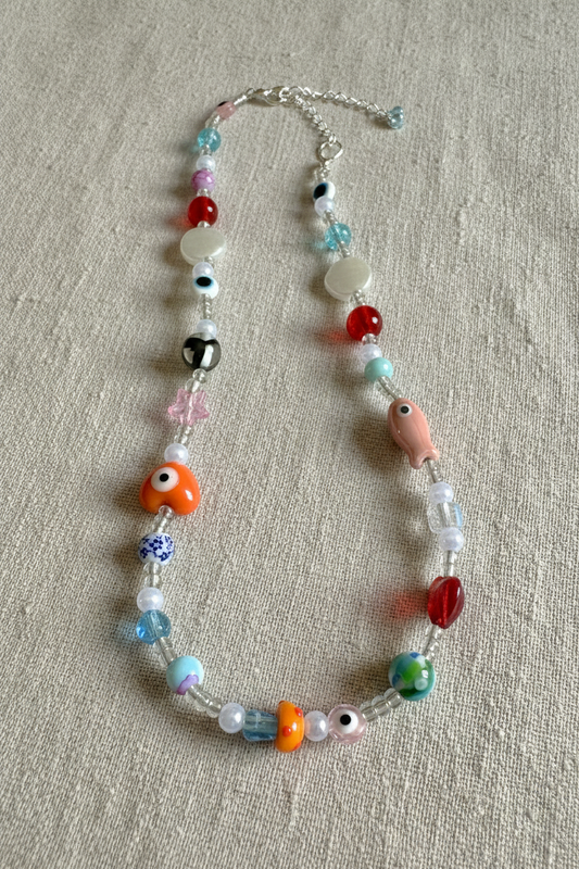 Colorful beaded necklace on a textured surface