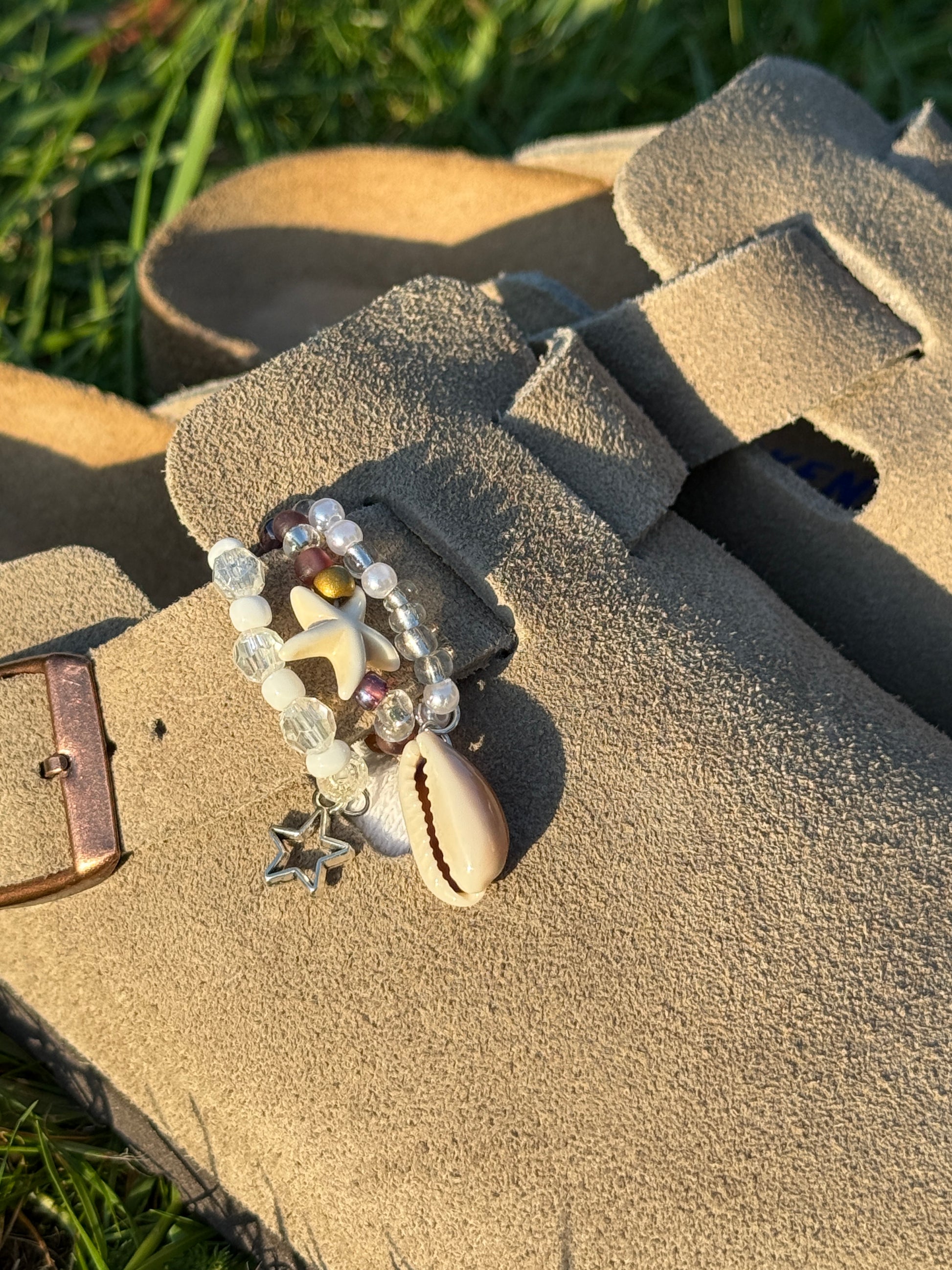 Close-up of a sandal with decorative elements on a grassy background