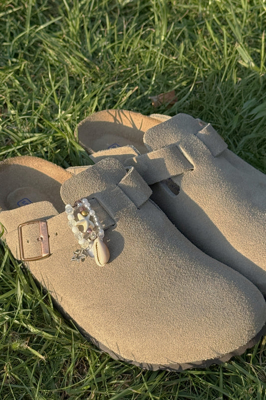 Beige suede shoes with decorative buckle on grass