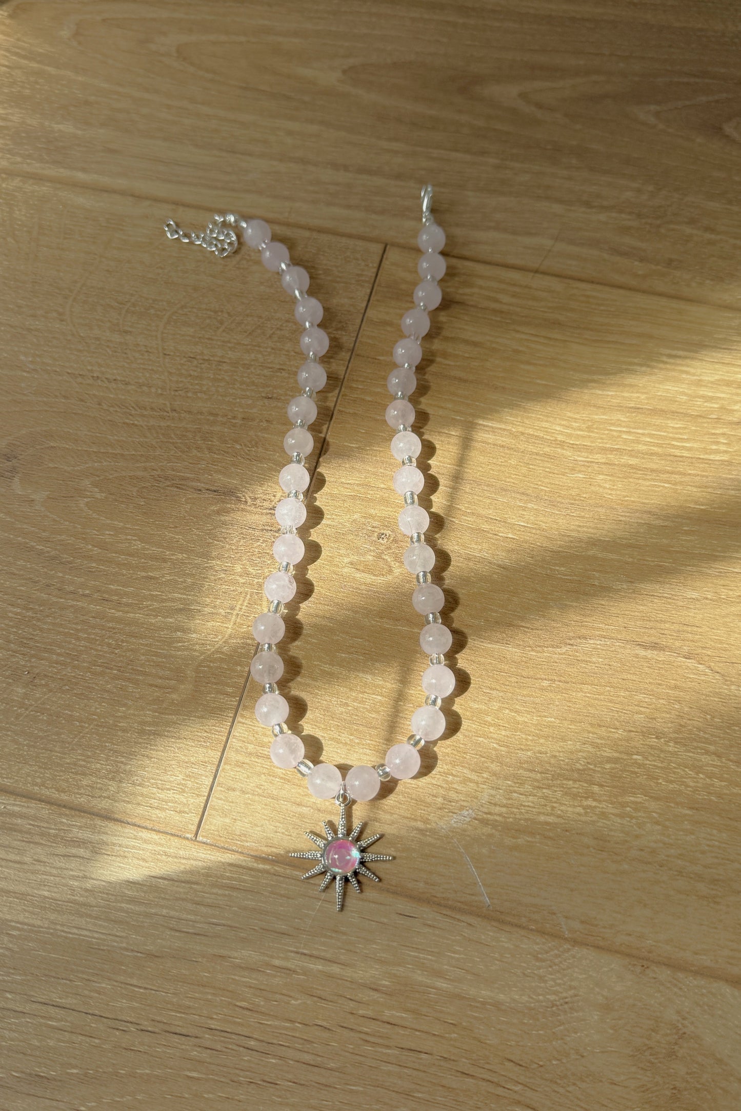 Necklace with a sun-shaped pendant on a wooden surface