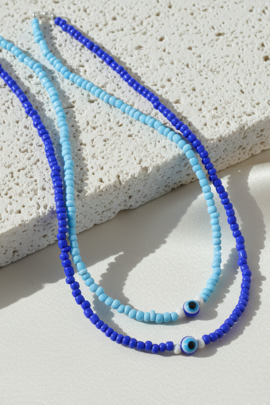 Blue and turquoise beaded necklace on a textured stone surface