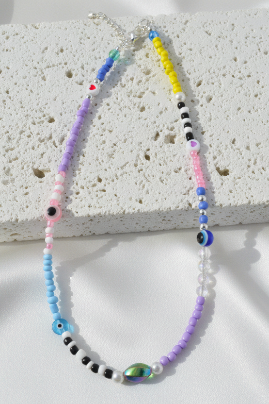 Colorful beaded necklace on a textured white surface